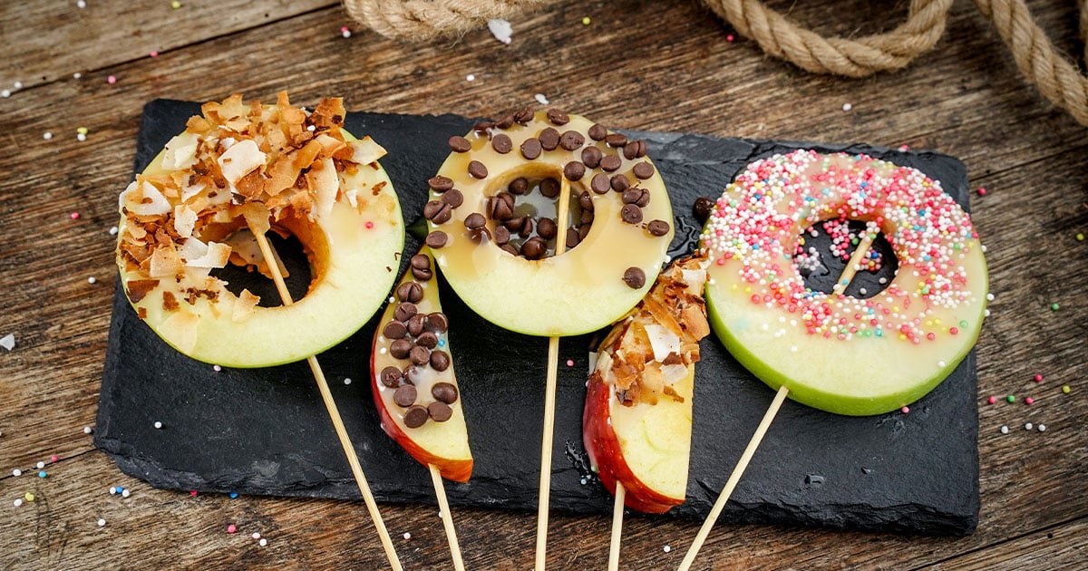 several Caramel Apples on a board
