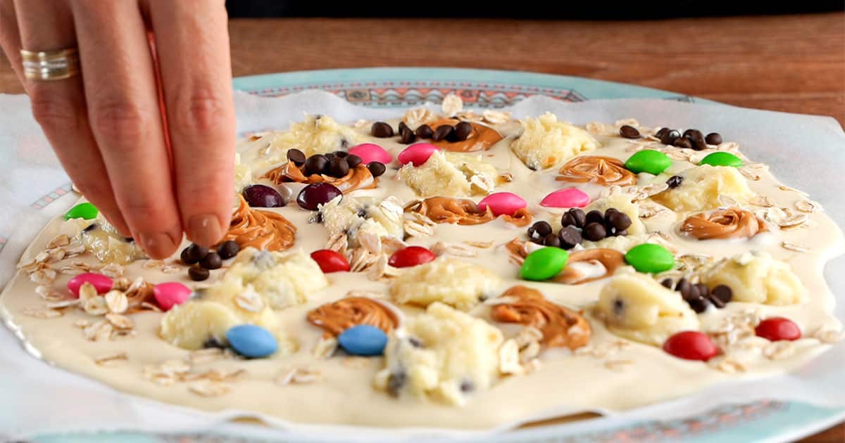 adding toppings to monster cookie bark