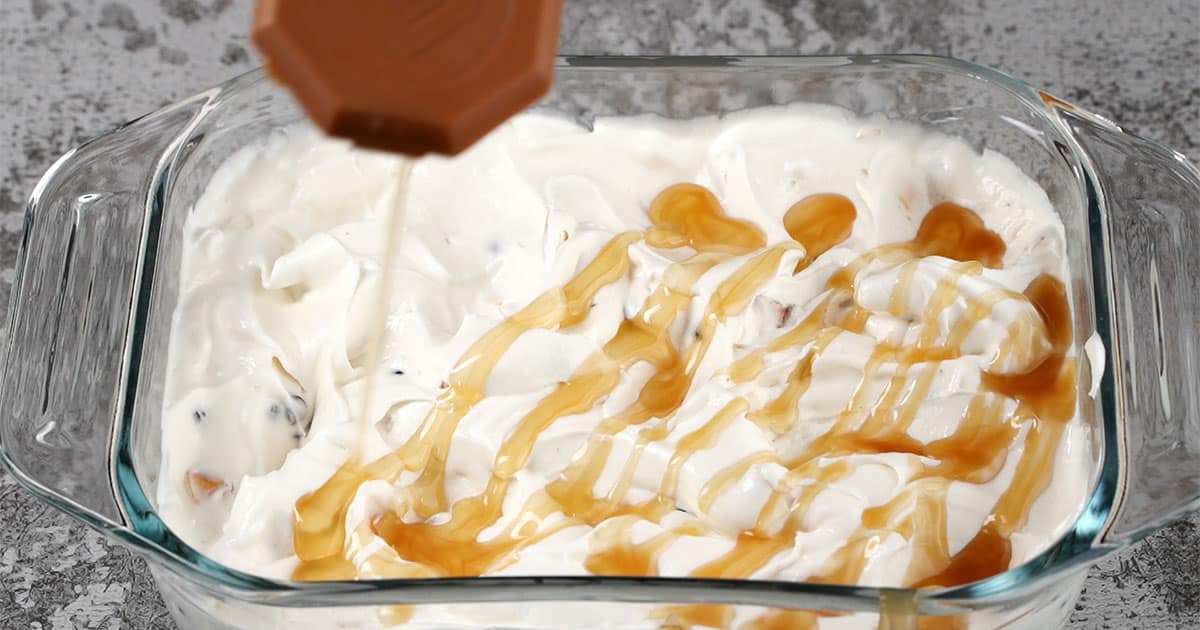 caramel being drizzled over samoa cheesecake dip
