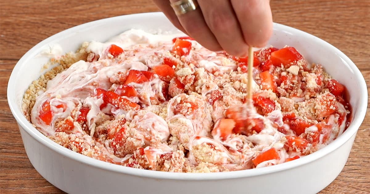 swirling ingredients together to make strawberry cheesecake ice cream