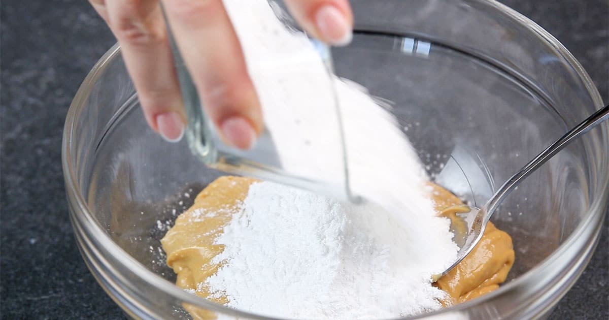 Pour sifted Powdered Sugar into Peanut Butter Ball mixture.