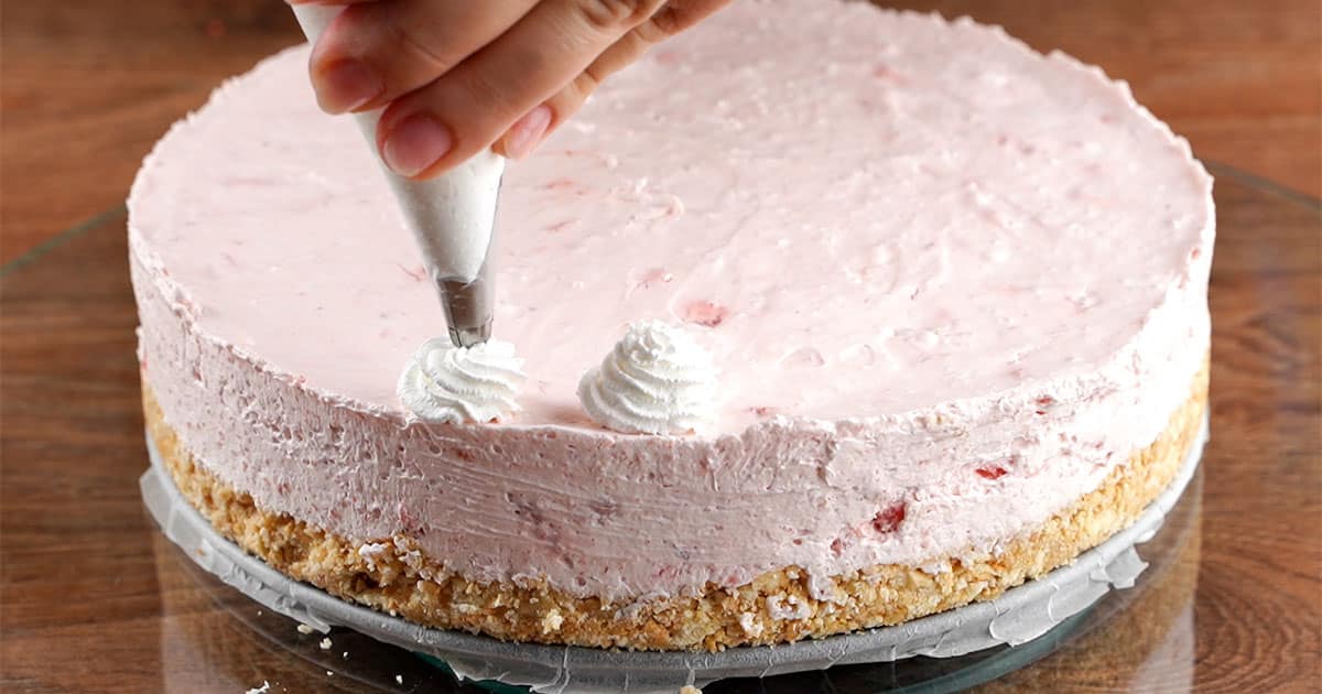 How to pipe on whipped cream rosettes onto the Strawberry Cheesecake.