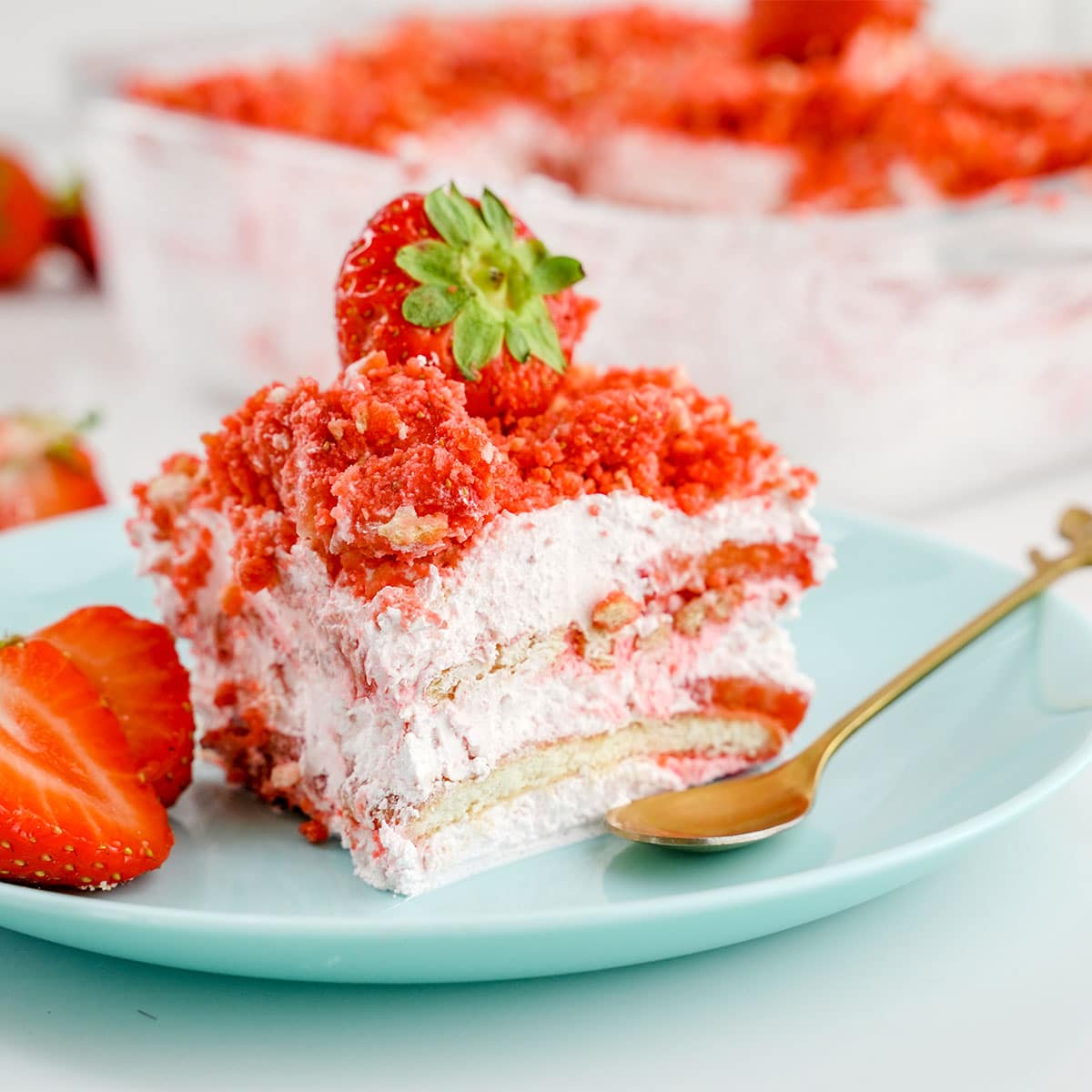side view of slice of the Strawberry crumble Icebox cake with spoon and strawberries.