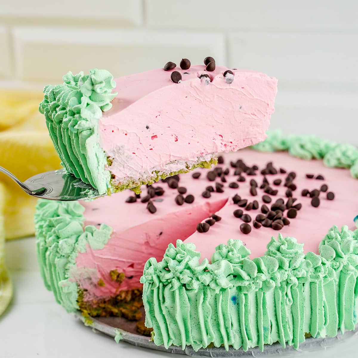 fresh cut slice of Watermelon Cheesecake on cake slicer.